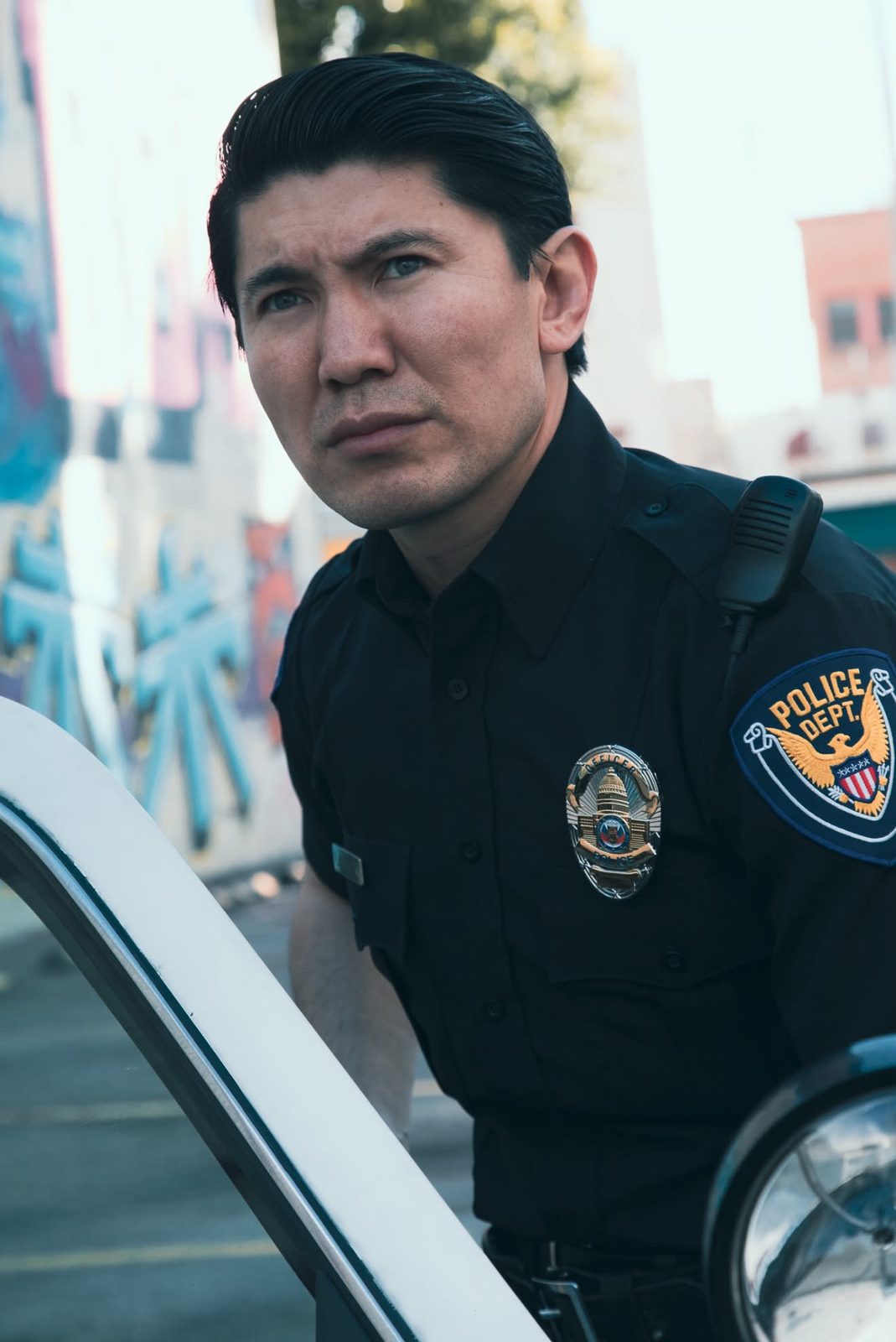 Medet Aman in a police uniform, looking past the camera
