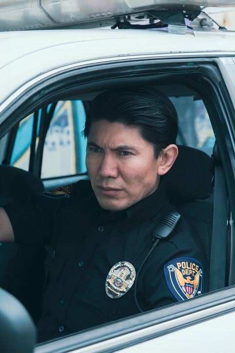 Medet in the driver's seat of a patrol car, looking out the window